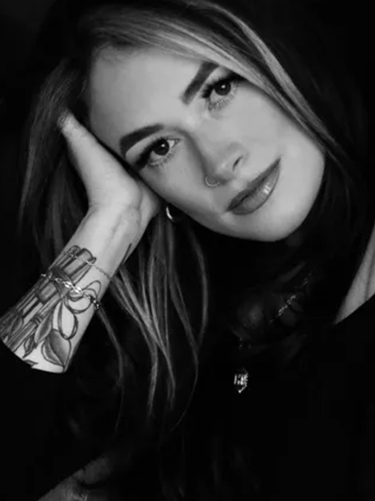 Hallie, Premier Artist at Envy Studio, showcasing her signature style and artistry in a close-up portrait.