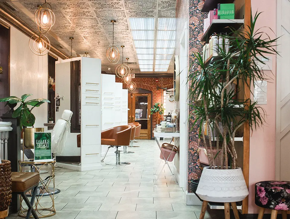 Stylish interior of Envy Studio hair salon in Lancaster, PA, featuring modern decor, salon chairs, and plants, creating a welcoming atmosphere for hair services.